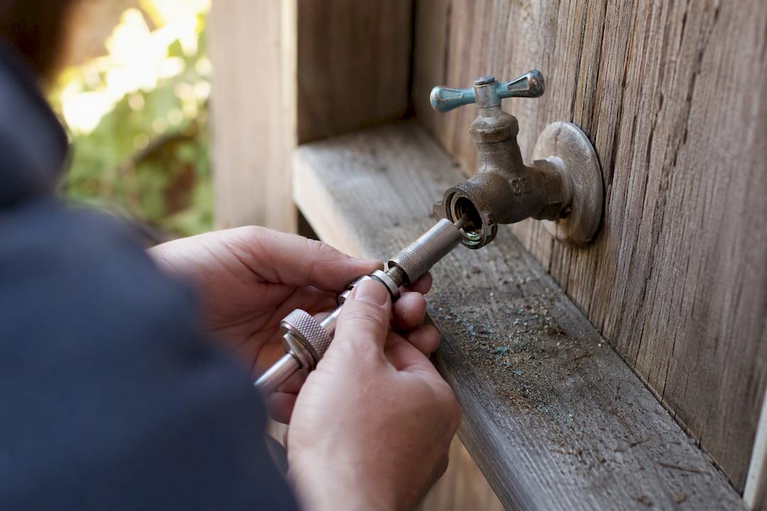 Hands using tool to resurface spigot valve seat
