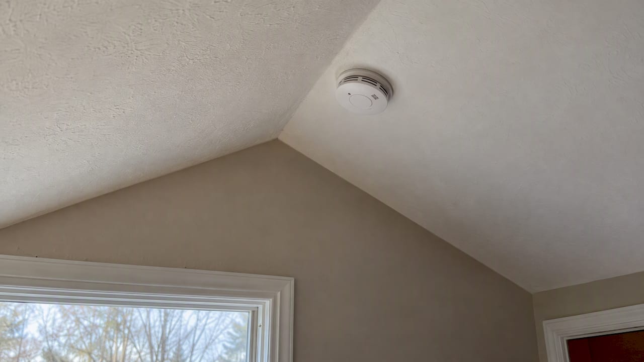 Smoke alarm mounted on pitched ceiling