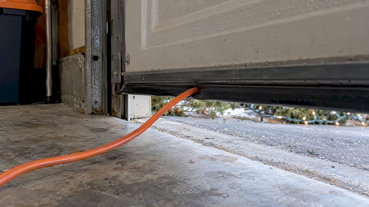 Extension cord pinched beneath garage door
